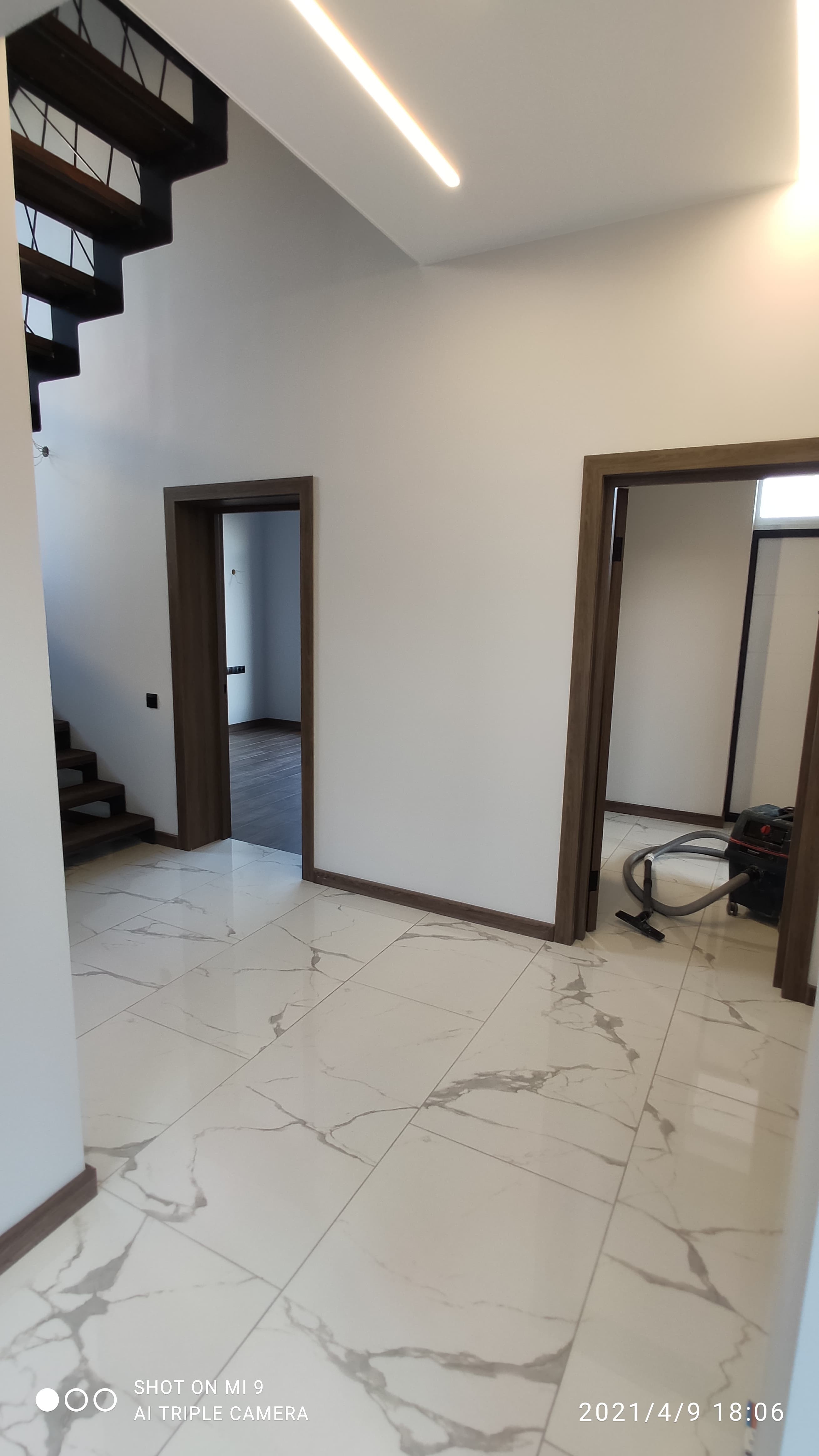 Холл с плиткой под мрамор и деревянными акцентами